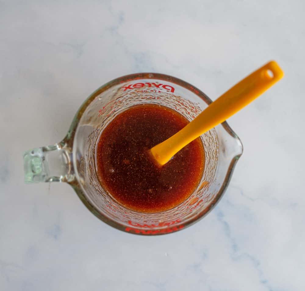 top view of a glass pyrex measuring up of sesame chicken sauce.