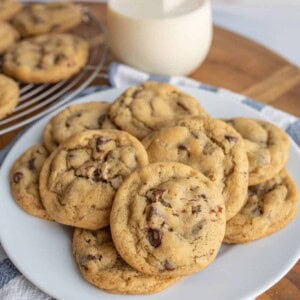 a plate stacked with chocolate chip cookies.