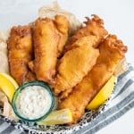 crispy golden deep fried and beer battered fish with tartar sauce and lemons