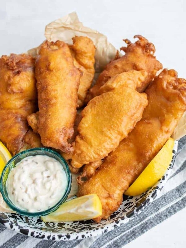 crispy golden deep fried and beer battered fish with tartar sauce and lemons