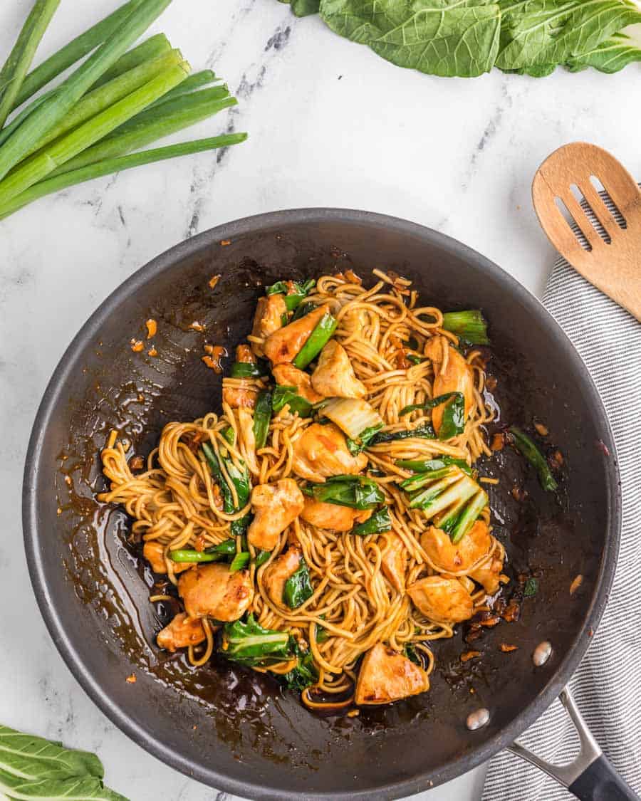 top view of chicken and lo main noodles in a pan.