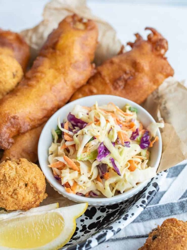 crispy deep fried snacks and a lemon with a dish of coleslaw as the center