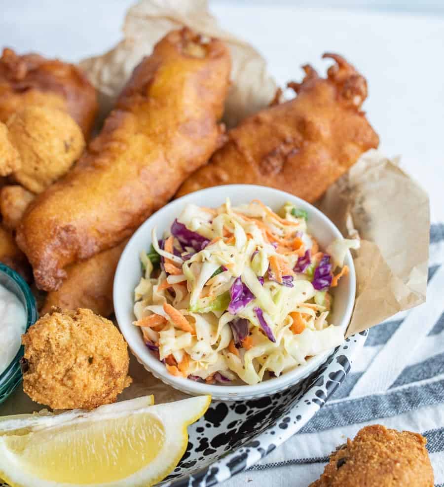 crispy deep fried snacks and a lemon with a dish of coleslaw as the center