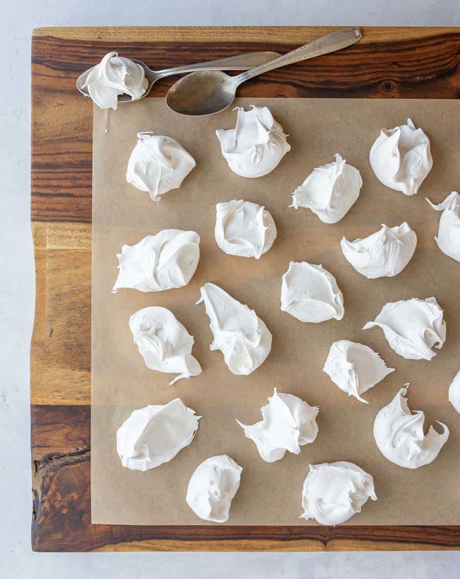 dollops of fluffy looking white divinity candy on parchment top view