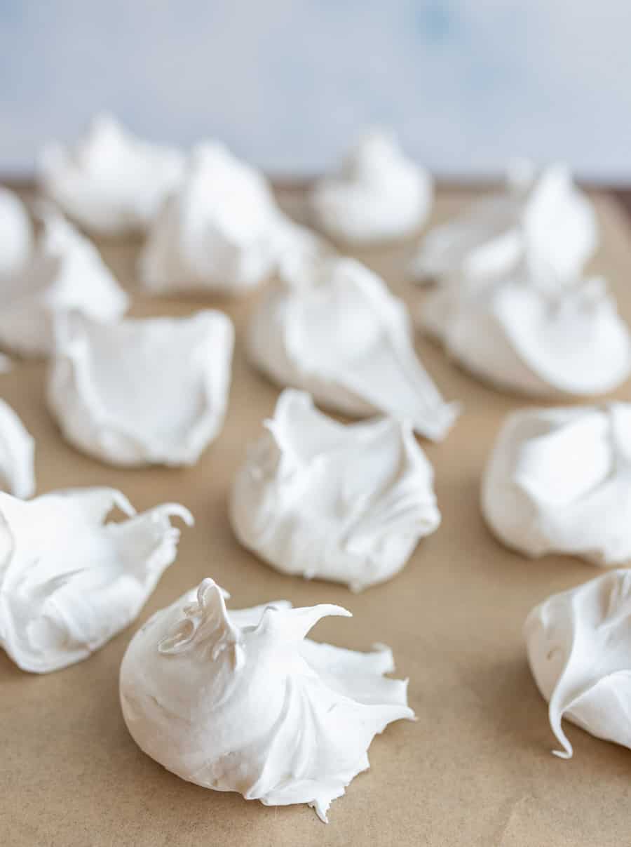 dollops of fluffy looking white divinity candy on parchment.