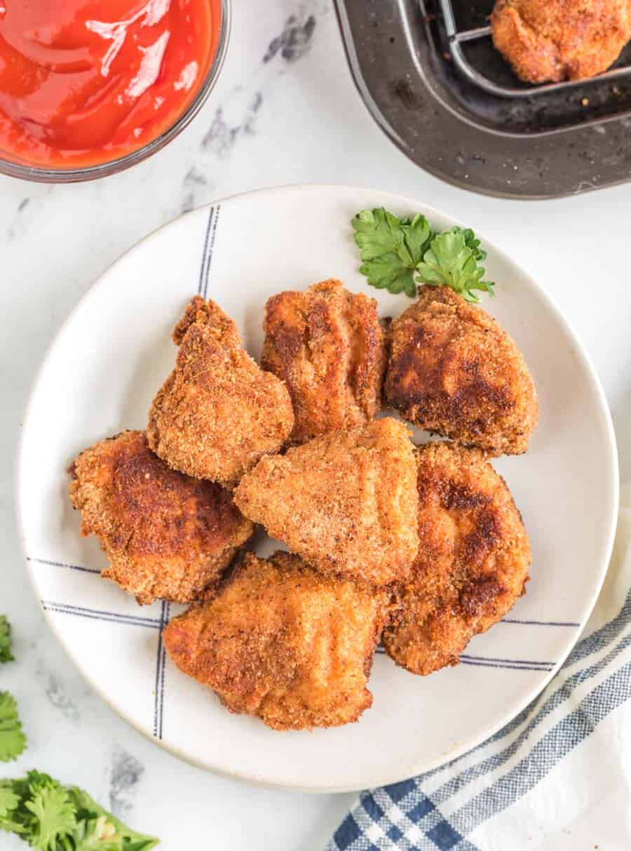 crispy fried and golden homemade chicken nuggets on a white plate