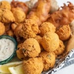 close up of the hush puppies with crispy fried beer batter fish in the background
