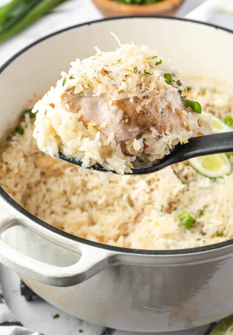 spoonful of rice over a white cast iron pot and a delicious looking green onion and lime with coconut rice dish