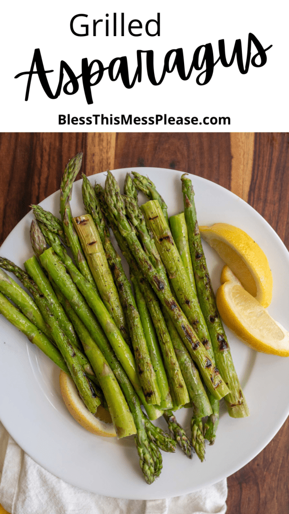 pin reads "grilled asparagus" and the marked and perfectly seasoned and grilled spears are stacked on a white plate next to lemon wedges