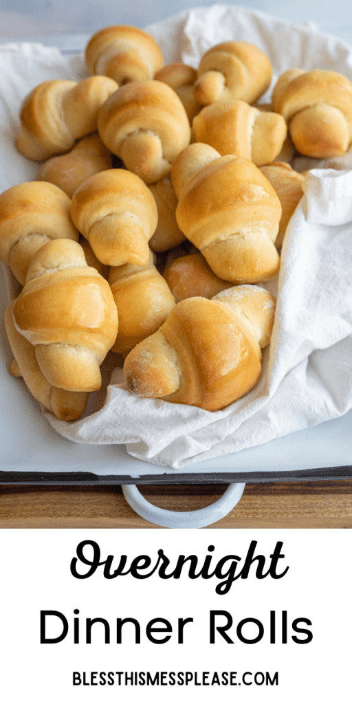 pin text reads "overnight dinner rolls" and baked and buttered croissant shaped rolls in a pile on parchment