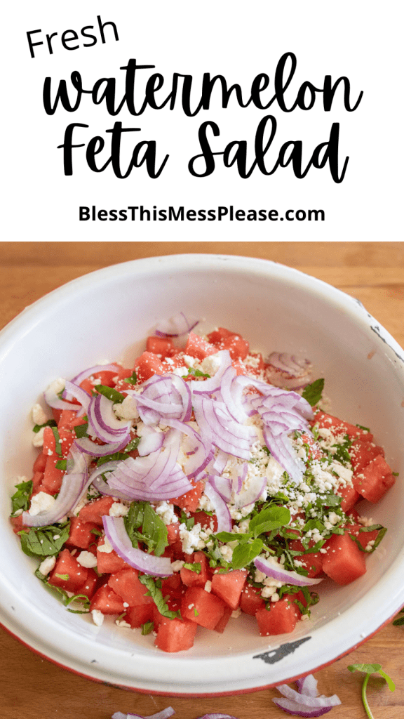 pin and the text reads "watermelon & feta salad" a photo of a white rustic bowl with wooden spoons of chunks of watermelon and feta, mint and purple onion