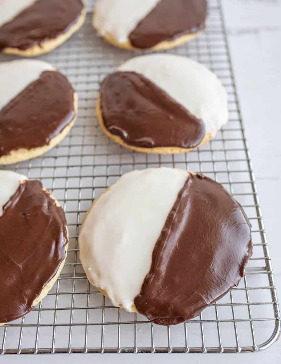 black and white iced cookies exactly half and half split of each color on a cooling rack