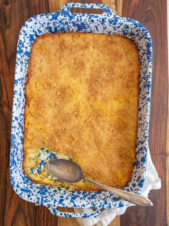 photo of a blue spotted baking dish with crumbly topped yellow squash casserole with one piece missing