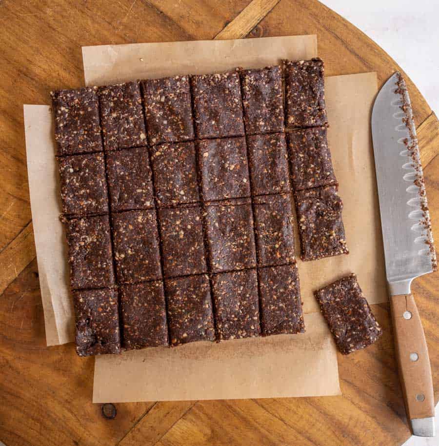 cutting squares out of the healthy date and nut snack bars on parchment