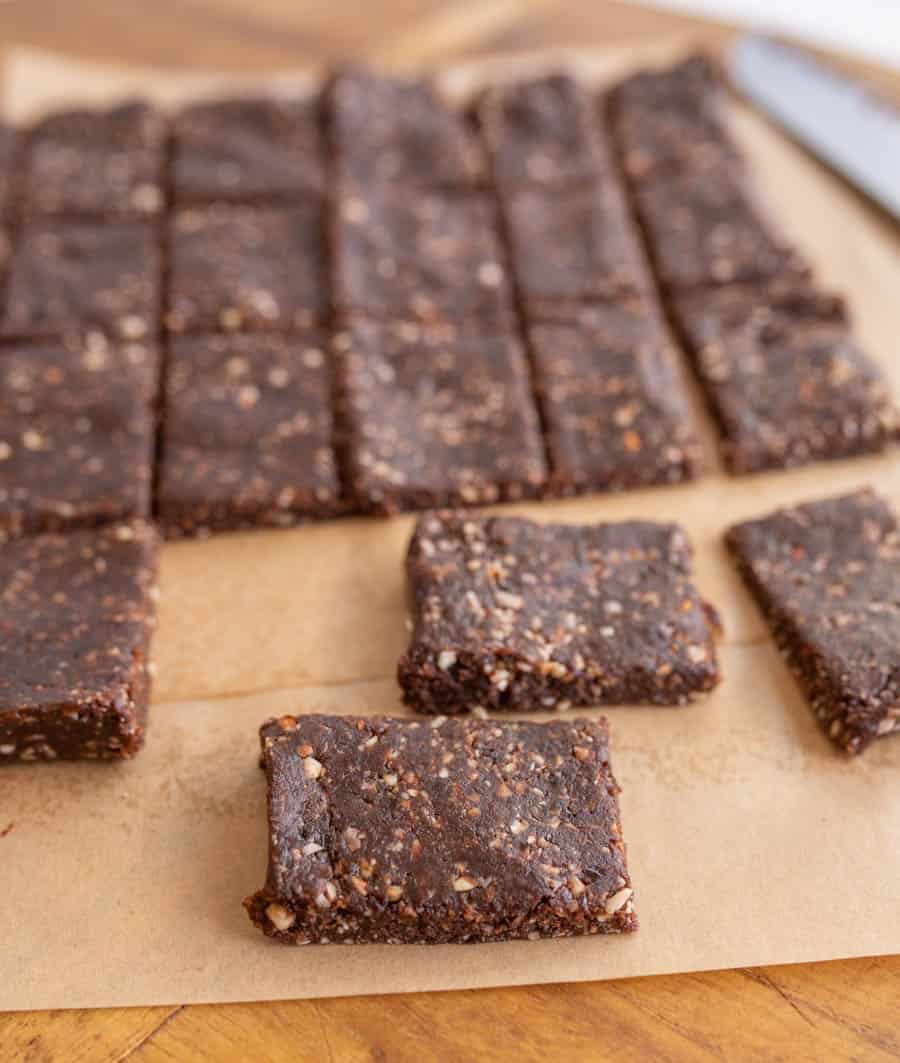 cutting squares out of the healthy date and nut snack bars on parchment