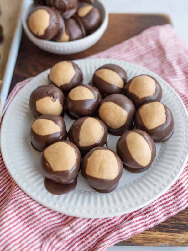 round truffle like chocolates piled on a pate and in a bowl with what looks like a lighter color to the shell of each