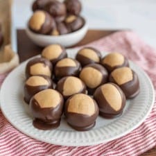 round truffle like chocolates piled on a pate and in a bowl with what looks like a lighter color to the shell of each