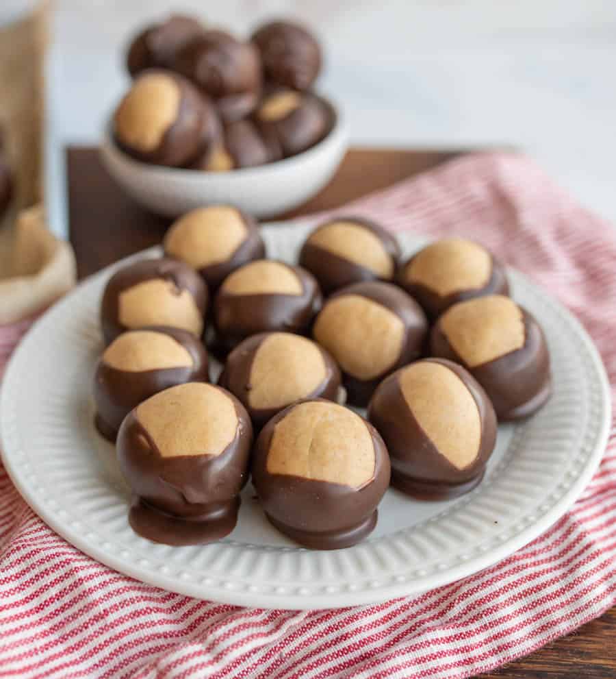 round truffle like chocolates piled on a pate and in a bowl with what looks like a lighter color to the shell of each