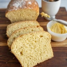 sliced airy potato bread with honey and butter in the background