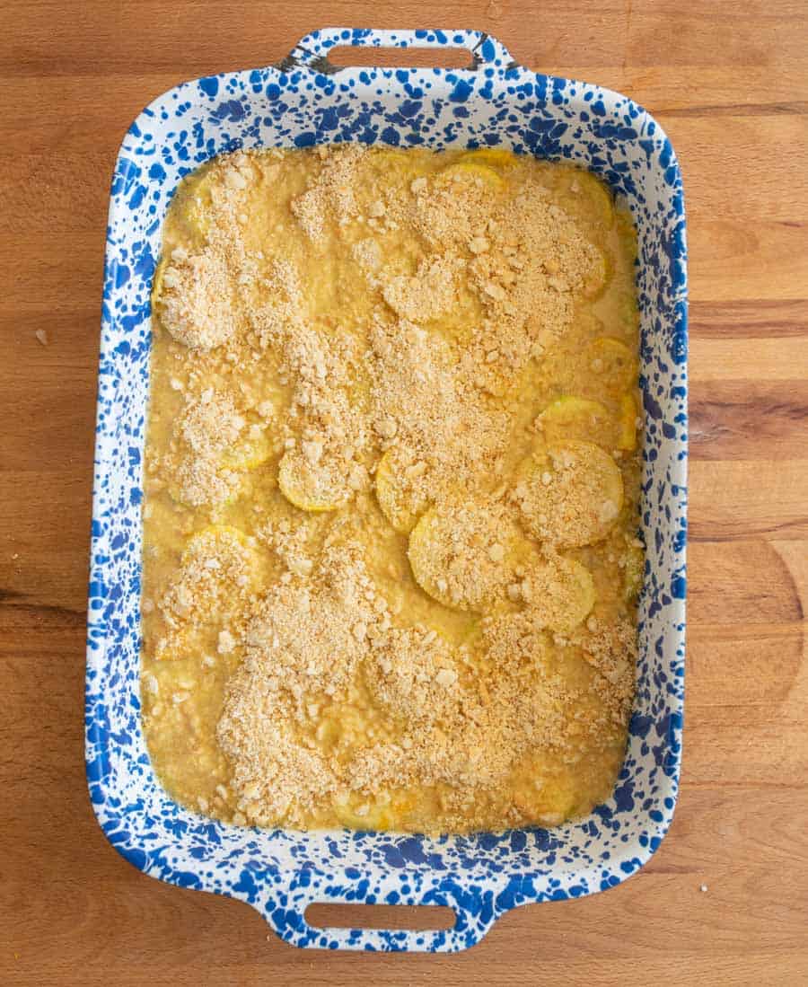 top view before baking - photo of a blue spotted baking dish with crumbly topped yellow squash casserole