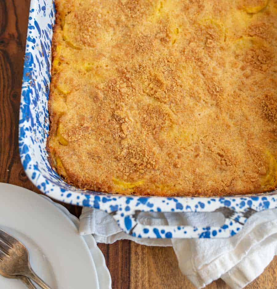 photo of a blue spotted baking dish with crumbly topped yellow squash casserole