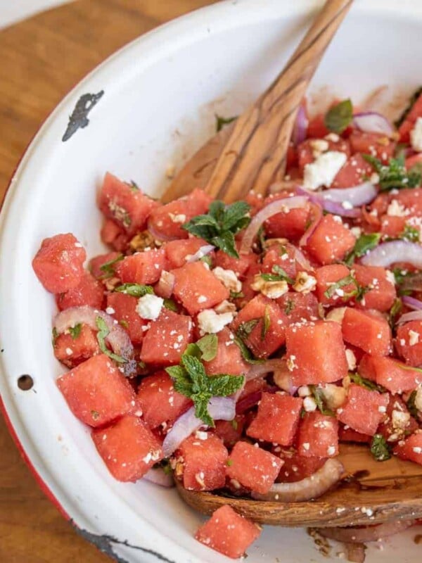 close up photo of the watermelon feta salad with wooden spoons