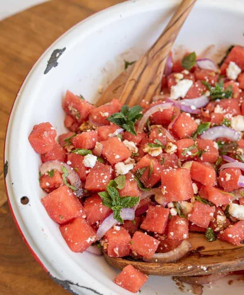 close up photo of the watermelon feta salad with wooden spoons