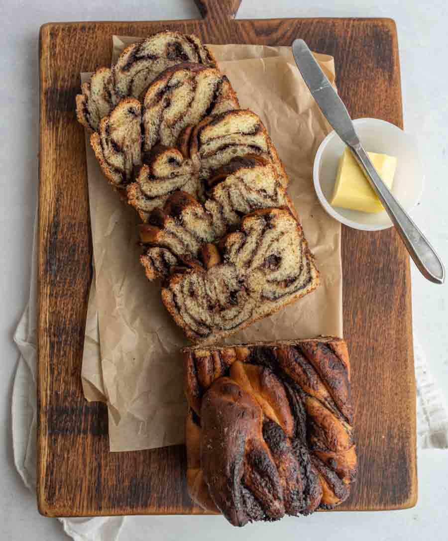 top view of chocolate loaf half sliced next to butter on a chopping block