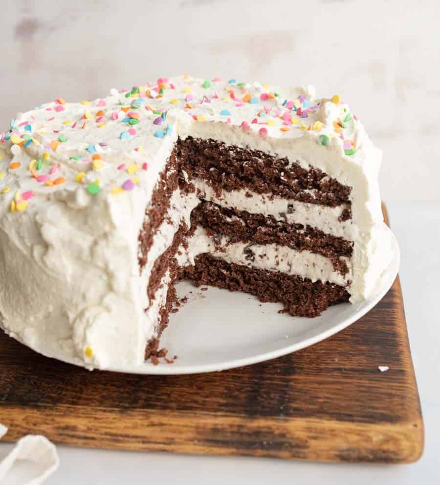 ¾ of an ice cream cake, chocolate cake and white frosting looking into the center