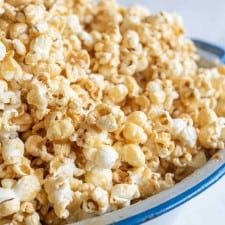 close up of soft caramel popcorn on a big white and blue bowl