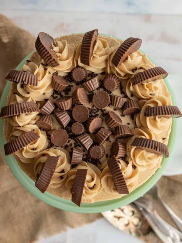 top view of a tan peanut butter frosting over a round cake with peanut butter cups on top