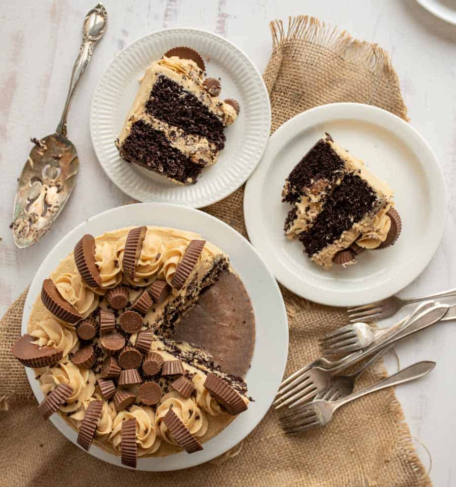 peanut butter cups on top of a cake with pieces cut out onto plates