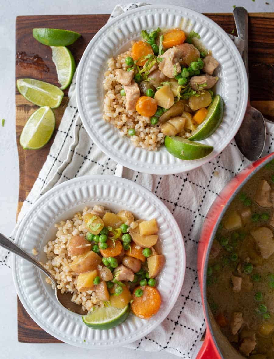 green curry over rice in white bowls