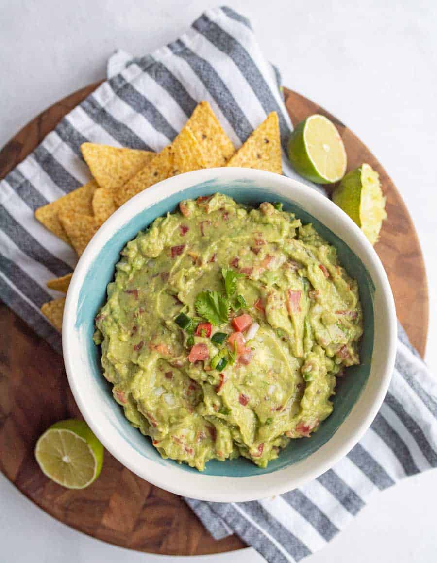 top view of bowl with guacamole and tortilla chips around it