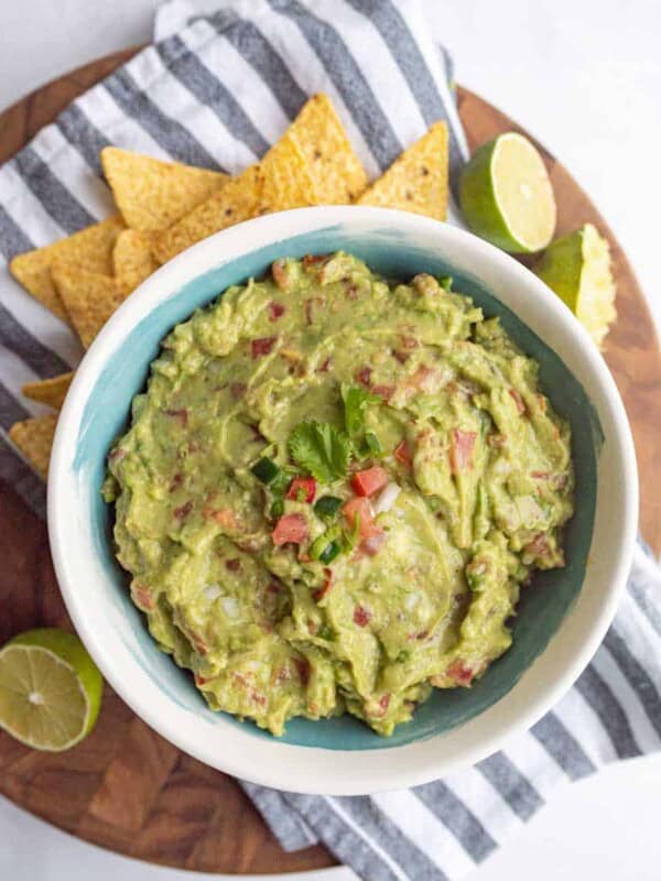 top view of bowl with guacamole and tortilla chips around it