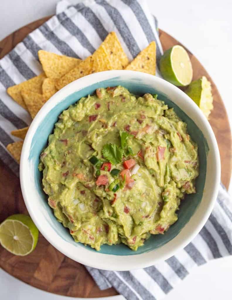 top view of bowl with guacamole and tortilla chips around it