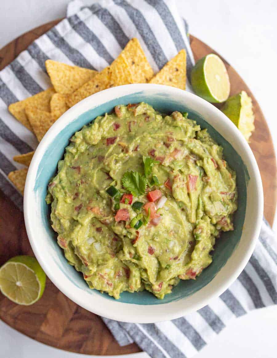 top view of bowl with guacamole and tortilla chips around it.