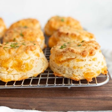 side view of cheddar biscuits on a cooling rack
