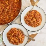 top view of two bowls of goulash and the whole pot next to it