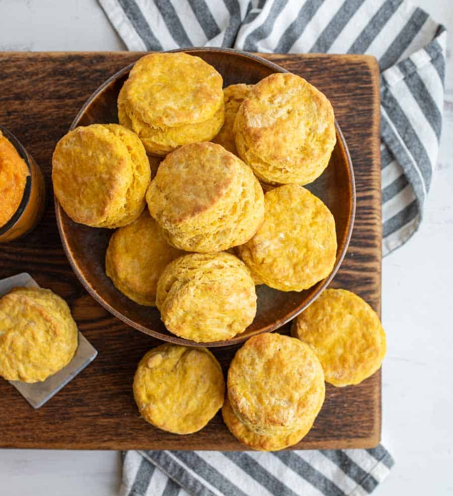 bowl of biscuits looking from the top down on a dark wood cutting board