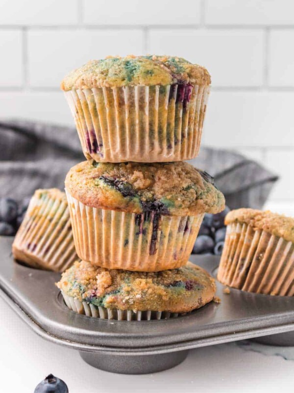 three homemade blueberry muffins stacked on top of each other