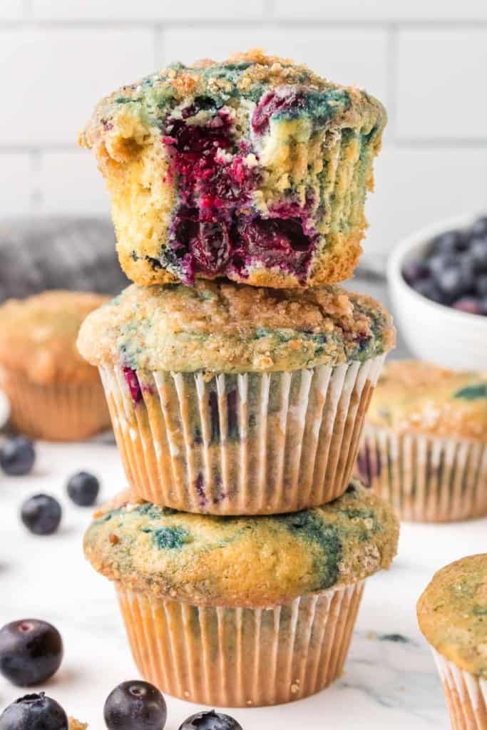 three homemade blueberry muffins stacked on top of each other