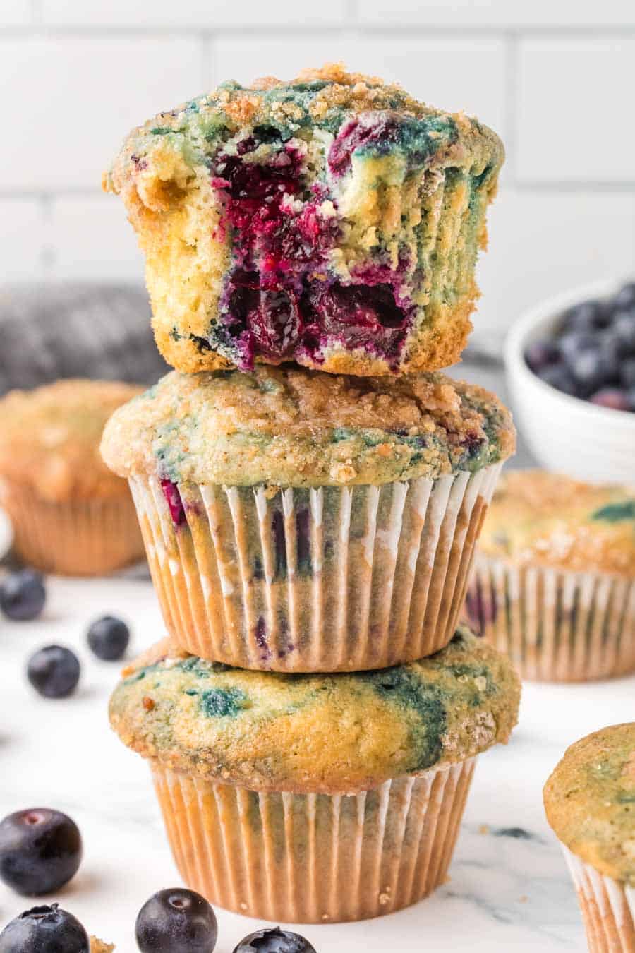 three homemade blueberry muffins stacked on top of each other