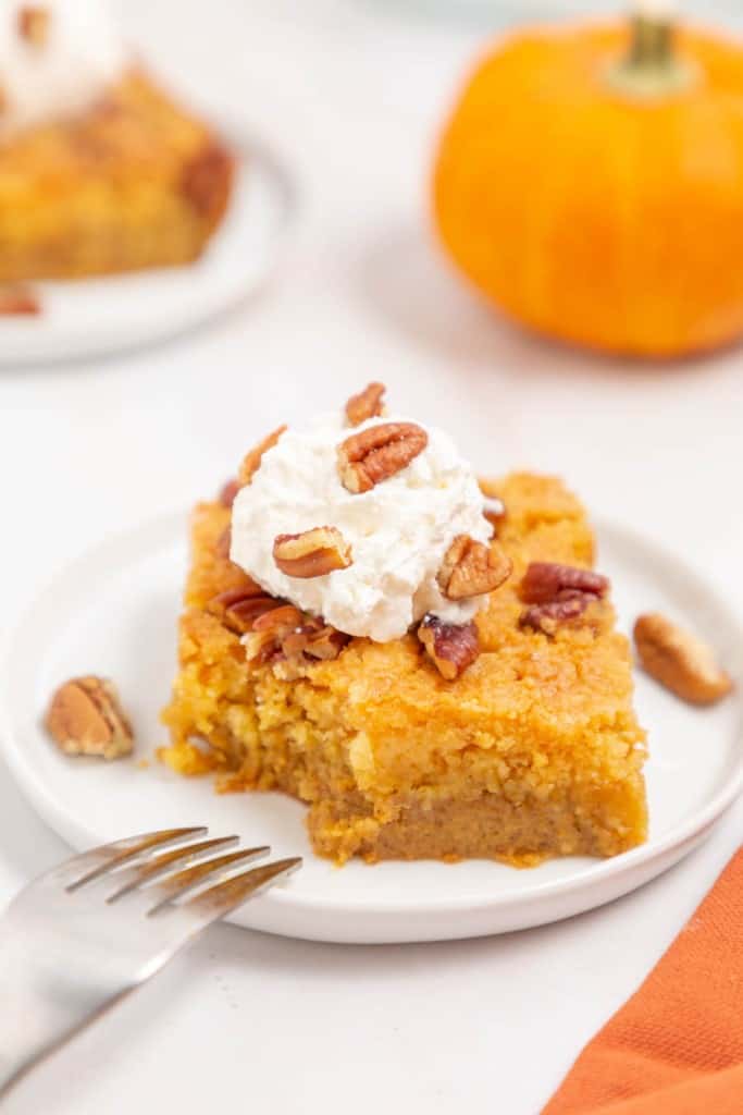 one square slice of a pumpkin dump cake with pecans on top