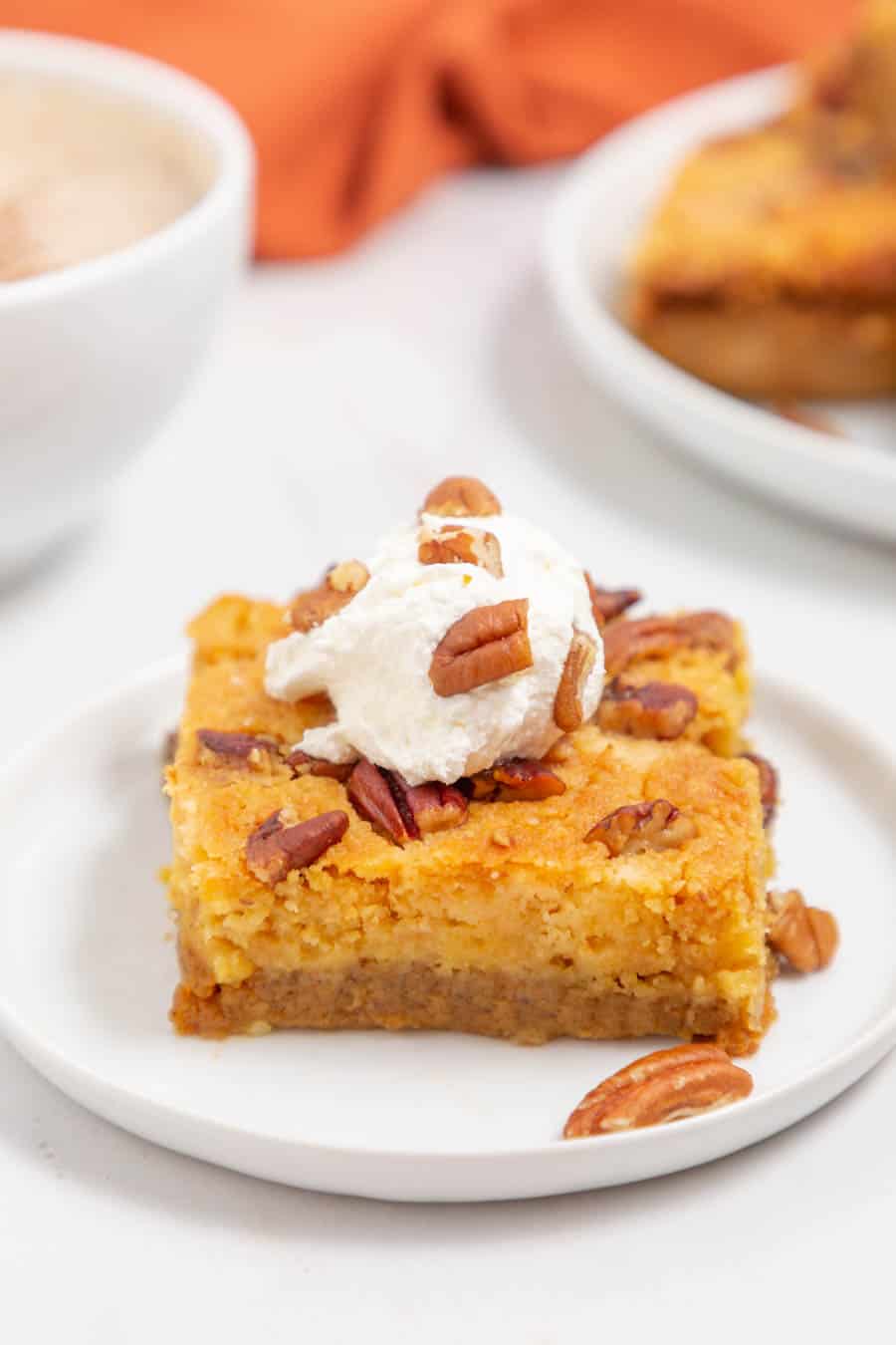 one square slice of a pumpkin dump cake with pecans on top