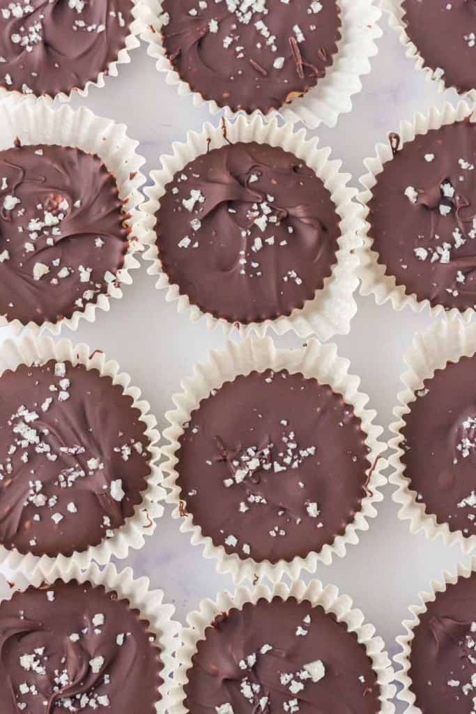 top view of homemade chocolate peanut butter cups in rows on a baking dish