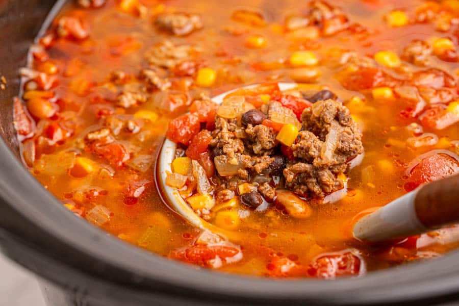slow cooker close up with a ladle of taco soup