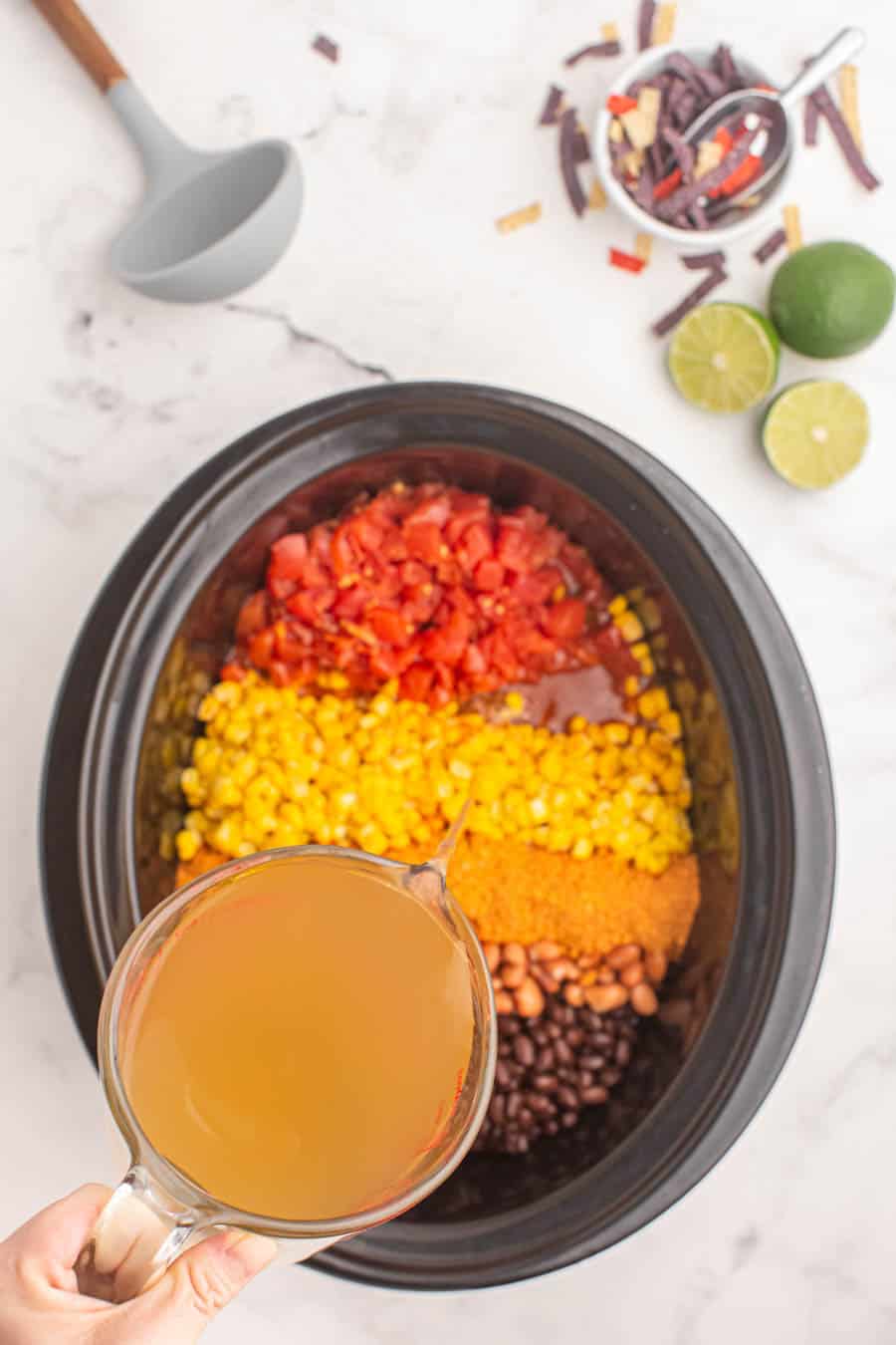 slow cooker with ingredients of taco soup inside before it is mixed together