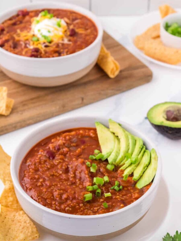 white bowl of vegetarian chili with avocado on top