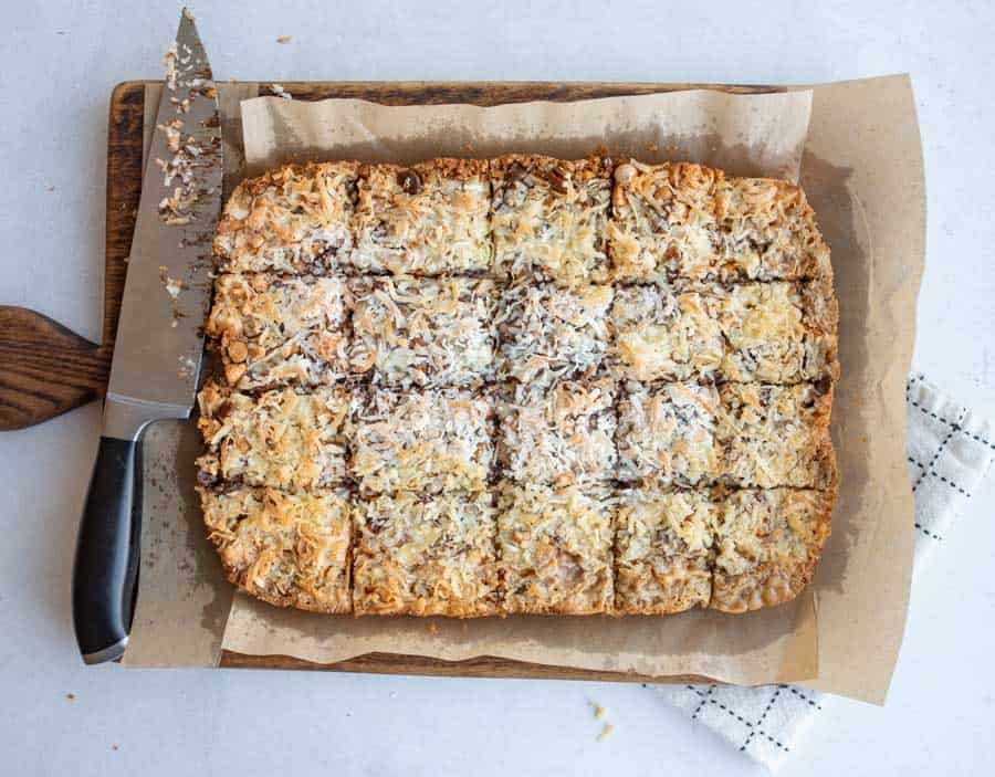 7 Layer Magic Bars being sliced into squares from the whole baked sheet